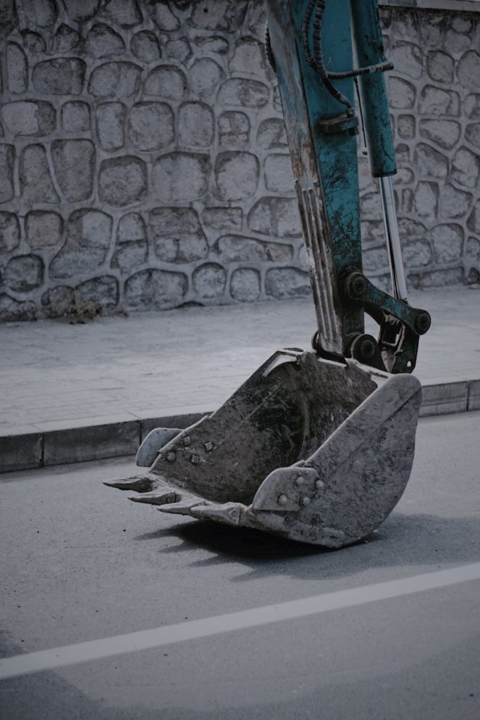 Photo by Kuan Fang closeup photo of excavator bucket on road